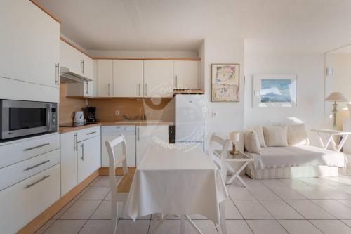 une cuisine et un salon avec une table et un canapé dans l'établissement AS9836 - P2 dans une résidence sur la plage avec belle vue sur le chenal et parking privé, au Grau-du-Roi