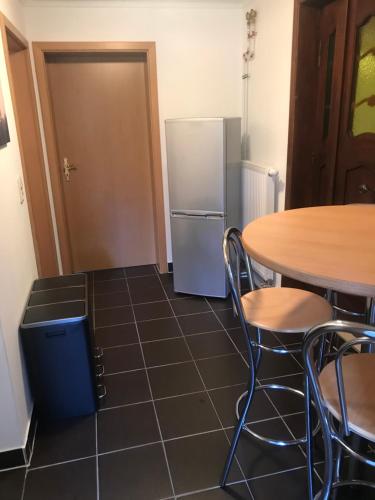 a kitchen with a table and a refrigerator at Wohnung 4 - klein aber fein - in Neustadt