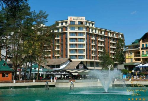 a fountain in the water in front of a building at King's Square Lux apartment Zlatibor 2 in Zlatibor
