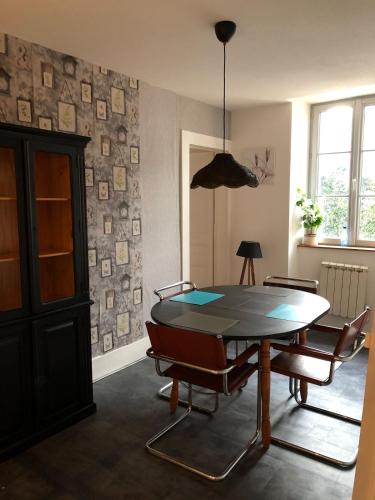 une salle à manger avec une table et des chaises dans l'établissement Au cœur de la perle du jura, à Champagnole