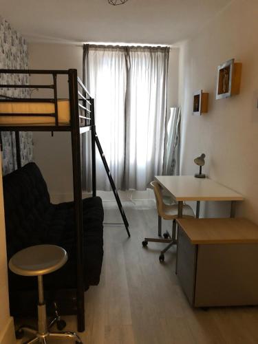 Ce dortoir comprend des lits superposés, un bureau et une table. dans l'établissement Au cœur de la perle du jura, à Champagnole