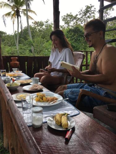 Ein Mann und eine Frau sitzen an einem Tisch mit Essen in der Unterkunft Little birds in Tangalle