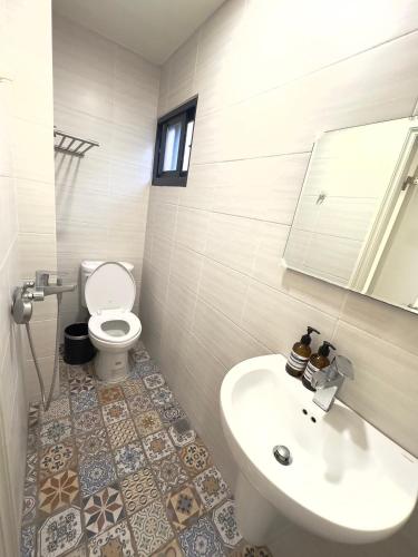 a bathroom with a sink and a toilet and a mirror at 隱居末巷 in San-fen-tzu
