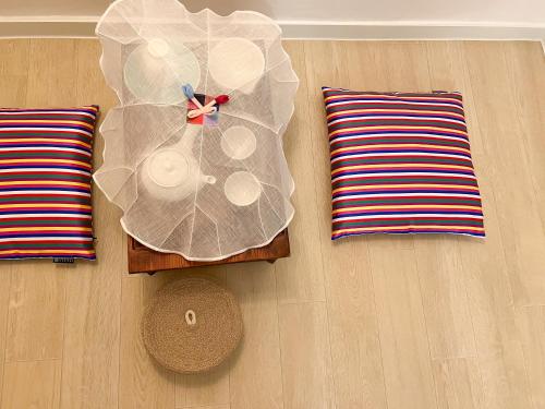a plastic clock on a table next to two pillows at JAJA Haenggung, SuwonㅣNext to Hwaseong FortressㅣCozy Korean VibeㅣComfortable & Well-keptㅣUp to 8 guestsㅣFree Parkingㅣ2-night minimumㅣLoved by many guests in Suwon