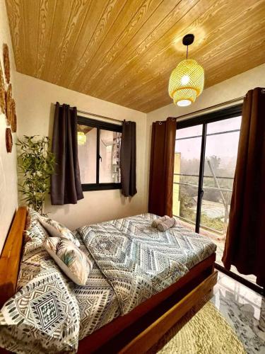 a bedroom with a bed and a large window at Mountain Sunctuary-TD Solo Unit for friends and family in Baguio