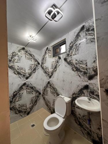 a bathroom with a toilet and a sink at Mountain Sunctuary-TD Solo Unit for friends and family in Baguio