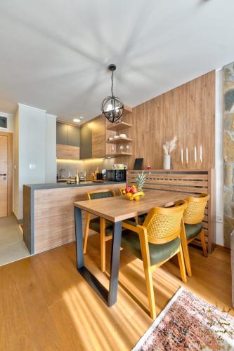 a kitchen with a wooden table and yellow chairs at King's Square Lux apartment Zlatibor 2 in Zlatibor