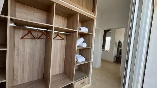 a walk in closet with wooden cabinets and towels at Villa La Falaise in Oualidia