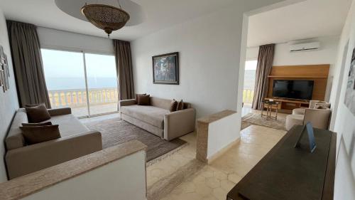 a living room with a couch and a television at Villa La Falaise in Oualidia