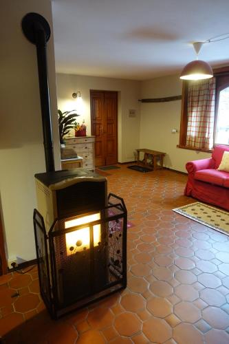 a living room with a fireplace and a red couch at La Dimora della Fontana in Mozzio