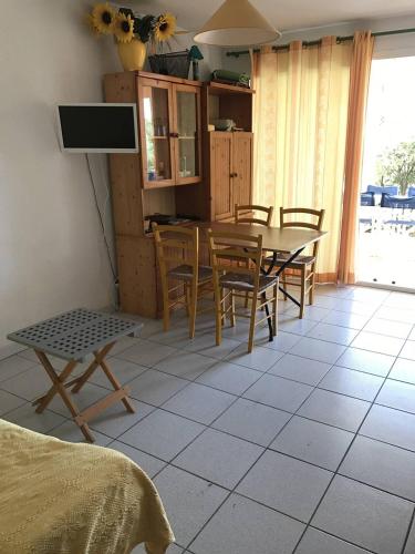 une cuisine avec une table et des chaises dans une pièce dans l'établissement AS8314 - P2 Cabine dans une résidence avec piscine, parking privé et belle vue chenal, au Grau-du-Roi