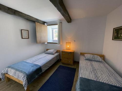 a bedroom with two beds and a table with a lamp at Casa do Paço in Paredes de Coura
