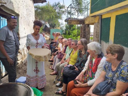 a group of older people sitting outside of a building at Roha Family Gust House in Lalībela