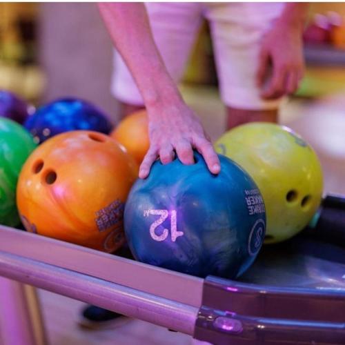 a person holding a bowling ball on a table at King's Square Lux apartment Zlatibor 2 in Zlatibor