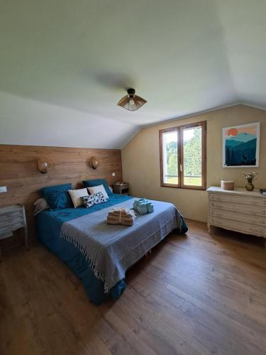 une chambre avec un lit bleu et une fenêtre dans l'établissement Maison vue sur lac en moyenne montagne, à Pradelles-Cabardès