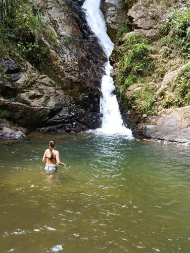 a woman in the water in front of a waterfall at Habitación en casa de campo via al aeropuerto in Copacabana