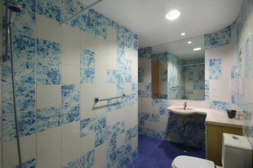a blue and white bathroom with a toilet and a sink at A Concha in Albufeira