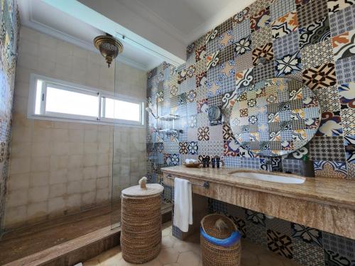 a bathroom with a sink and a mirror on the wall at Villa La Falaise in Oualidia
