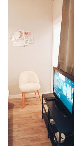 a living room with a chair and a television at Po1-TPSA17-3D- ROOM Paris 17ème in Paris