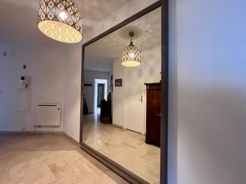 un miroir dans un couloir avec deux lustres dans l'établissement Appartement 2 Chambres, en bord de Mer, à Toulon