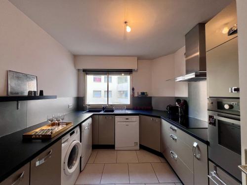 une grande cuisine avec un lave-linge et un sèche-linge. dans l'établissement Appartement 2 Chambres, en bord de Mer, à Toulon