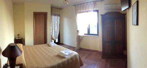 a bedroom with a bed and a window at Piccola Dimora Villa Candido in Stilo