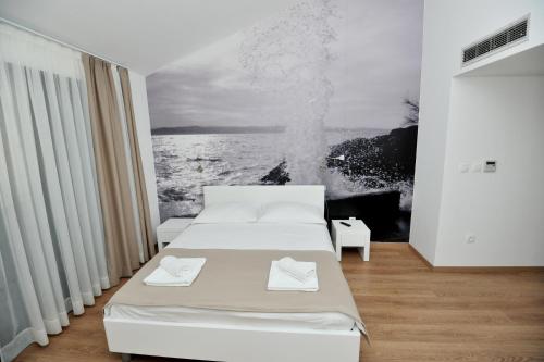 a room with two beds and a picture of the ocean at Villa Tomislav 2 in Brela