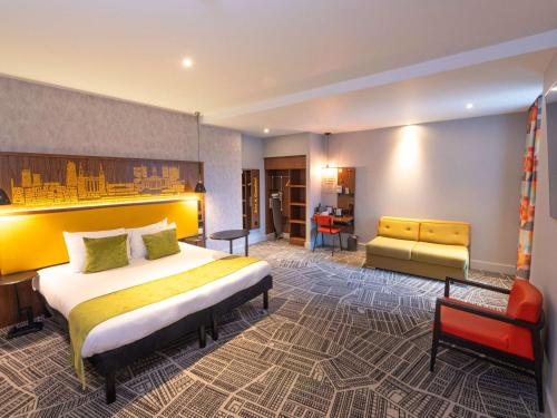 a hotel room with a bed and a couch at ibis Styles Leeds City Centre Arena in Leeds