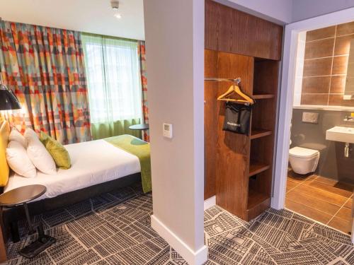 a hotel room with a bed and a bathroom at ibis Styles Leeds City Centre Arena in Leeds