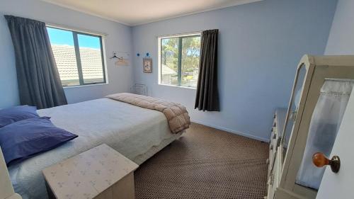 Ένα ή περισσότερα κρεβάτια σε δωμάτιο στο Room for The Family - Bowentown Bach