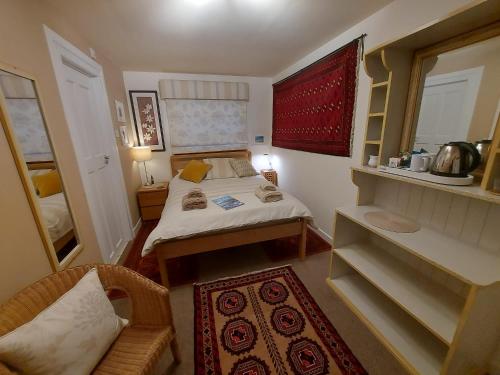 a small bedroom with a bed and a chair at Garragh Mhor in Oban