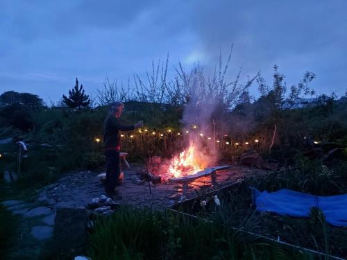 a man standing next to a fire at night at Garragh Mhor in Oban