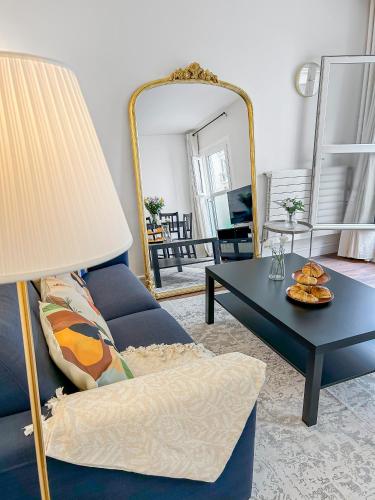 un salon avec un canapé bleu et une table dans l'établissement L'écrin d'Ivry, à Ivry-sur-Seine