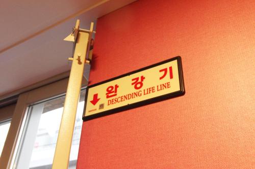 a sign on the side of a red wall at Dongseongro ZERO guesthouse in Daegu