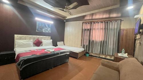 a bedroom with a bed and a couch in it at HOTEL Royal Plaza in Chandīgarh