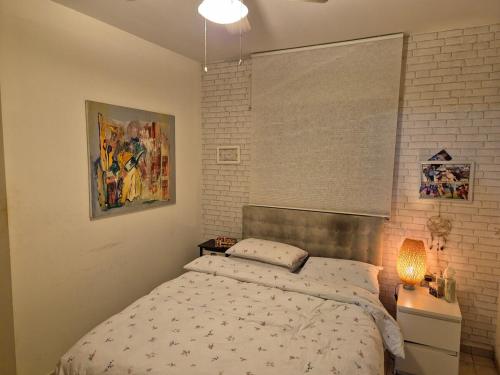 a bedroom with a bed and a lamp in it at Great Rental near Poleg Beach in Netanya