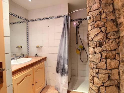 La salle de bains est pourvue d'un lavabo et d'une douche avec rideau de douche. dans l'établissement Sur les hauteurs de Théoule villa avec une magnifique vue mer, à Théoule-sur-Mer