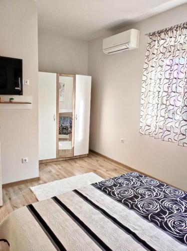 a bedroom with a large bed and a window at VN Home 2 in Pomorie
