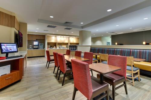 a restaurant with a table and chairs and a bar at TownePlace Suites by Marriott Mobile Saraland in Saraland