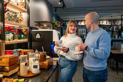 Un hombre y una mujer de pie en el mostrador de una tienda en Rezydencja AQUA by GRANO, en Szklarska Poręba