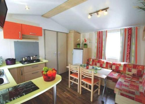 une cuisine et un salon avec une table et une salle à manger dans l'établissement Camping - Piscine - ccag0gh, à La Faute-sur-Mer