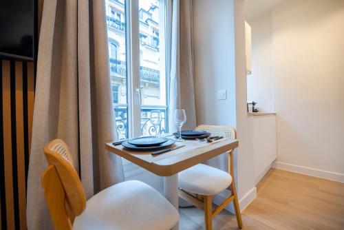 une petite table avec deux chaises et une fenêtre dans l'établissement CIA - Studio de l'Étoile, à Paris