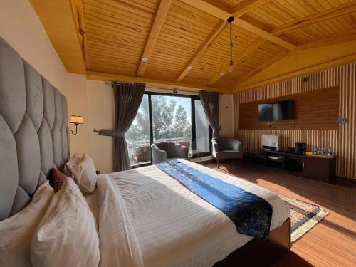 Royal Luxus في Nathia Gali: غرفة نوم بسرير كبير مع نافذة كبيرة