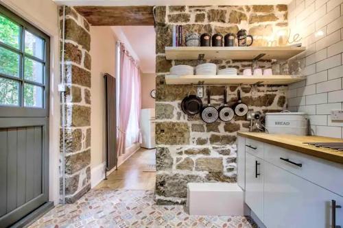 a kitchen with a stone wall and a counter top at West End Holiday Homes in Glasgow