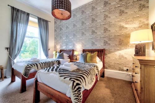 two beds in a bedroom with zebra print walls at West End Holiday Homes in Glasgow