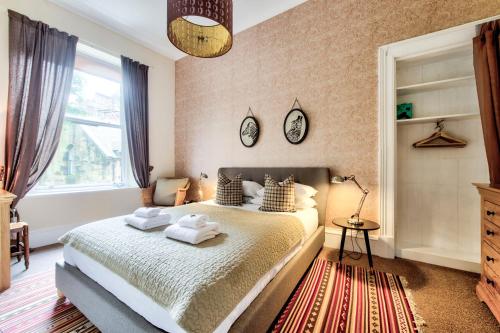 a bedroom with a bed with towels on it at West End Holiday Homes in Glasgow