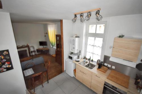 a kitchen with a sink and a table in a room at Maison confortable Souvigny + Jardin in Souvigny