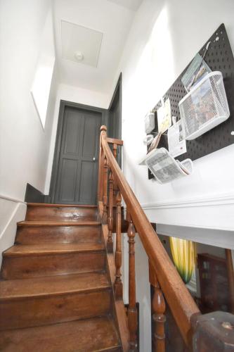 a stairway with wooden stairs and a black door at Maison confortable Souvigny + Jardin in Souvigny
