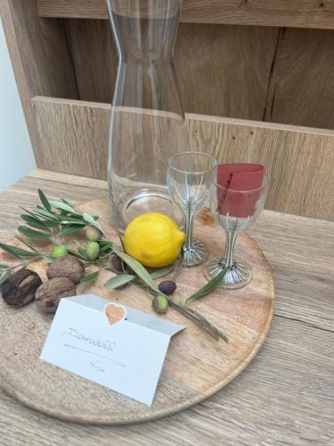 a table with a plate with glasses and a lemon at Korcula Apartment direkt am Meer -Zrnovska banja -2,5 km zur Altstadt Korcula in Korčula