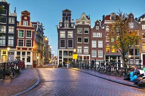 a cobblestone street in a city with buildings and bicycles at Houseboat Maatrollie NS002 in Monnickendam
